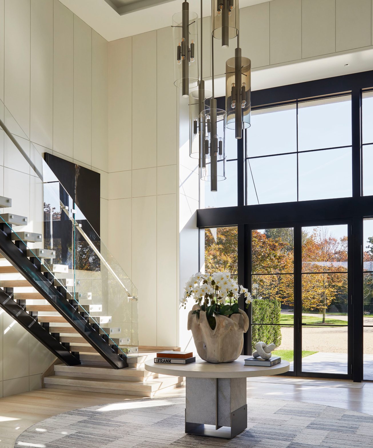 Large home entryway with big windows and a circular custom Stark rug in the middle.