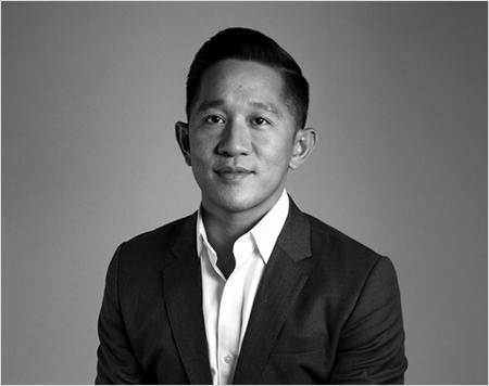 Black and white portrait of a man wearing a blazer and white collared shirt.