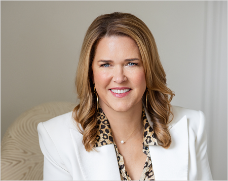 Woman wearing a white blazer over a leopard print top with a neutral background