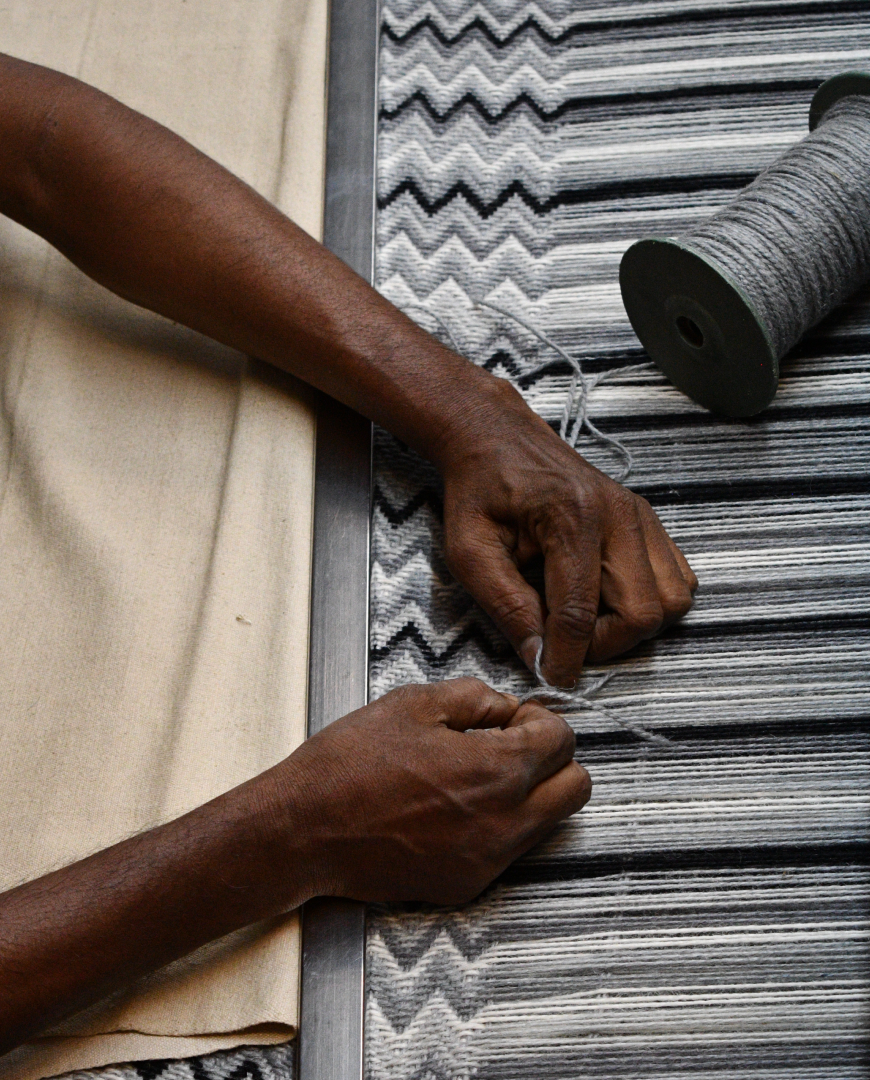 Hands creating a rug