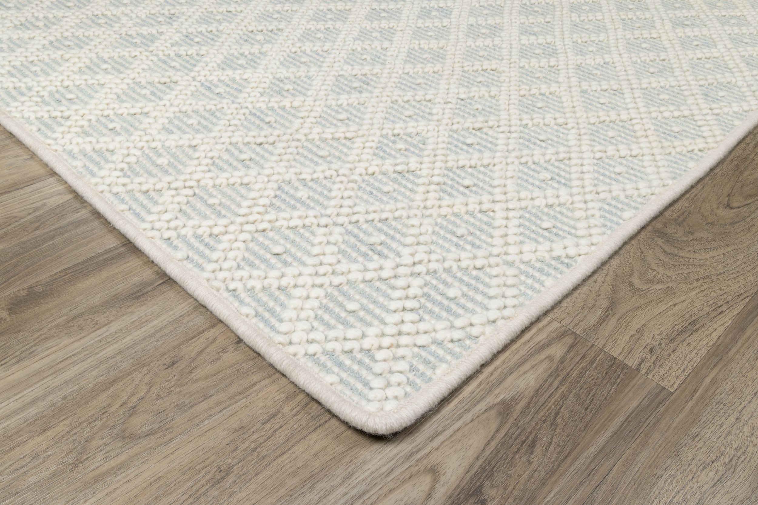 Corner of light colored pattern rug from STARK
